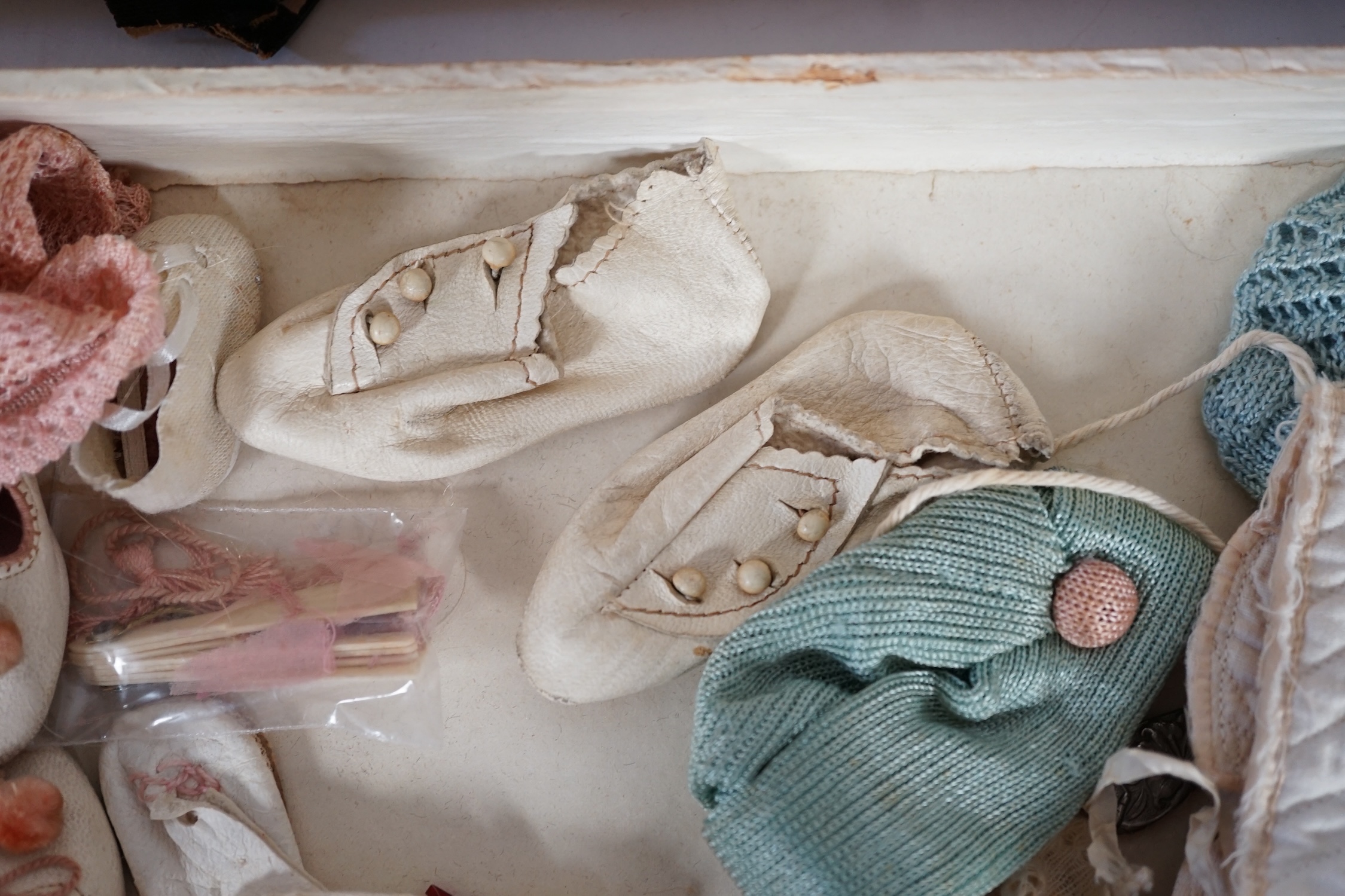 A doll's trunk with assorted vintage clothes, shoes and doll's accessories